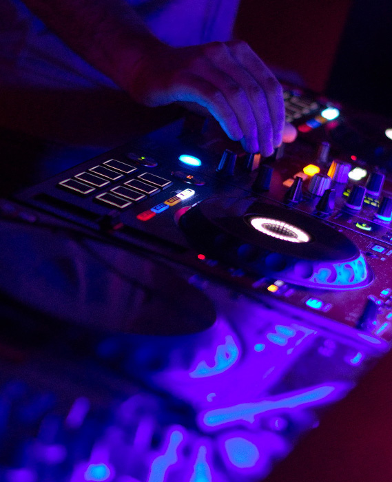 closup of the mixing console with the hand of the dj visible (Photo)