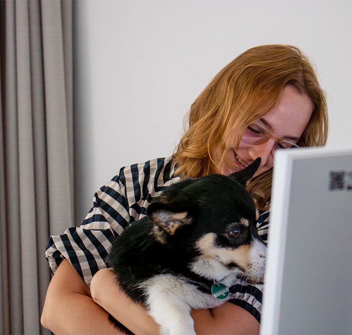 person with glasses supporting one of the office dogs in their barketing work (Photo)