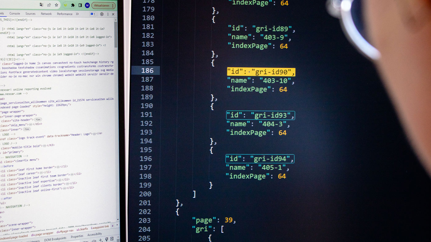 closeup of a person looking at html code and JSON blocks on two computer screens (Photo)